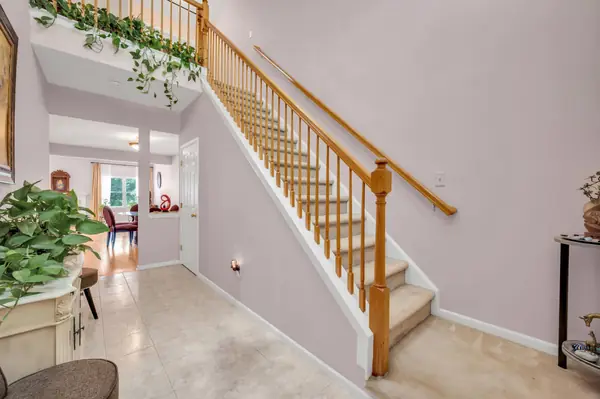 Entry foyer with hardwood floors and staircase