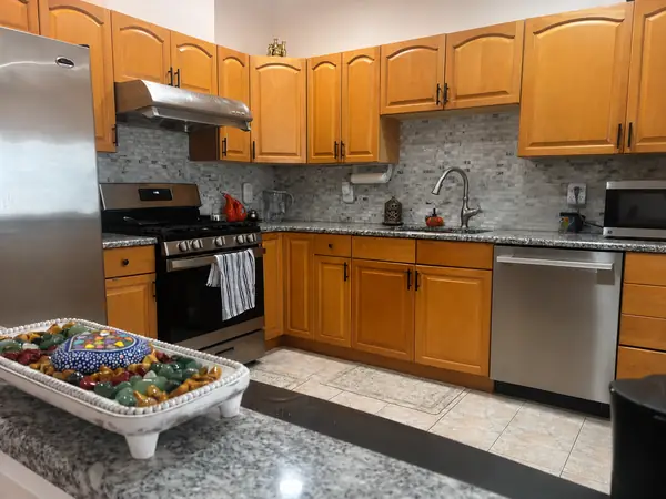 Kitchen with granite counters, gas range and tile backsplash